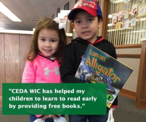 A little boy and girl stand together. The boy is holding a book that is titled "I Am An Alligator" 