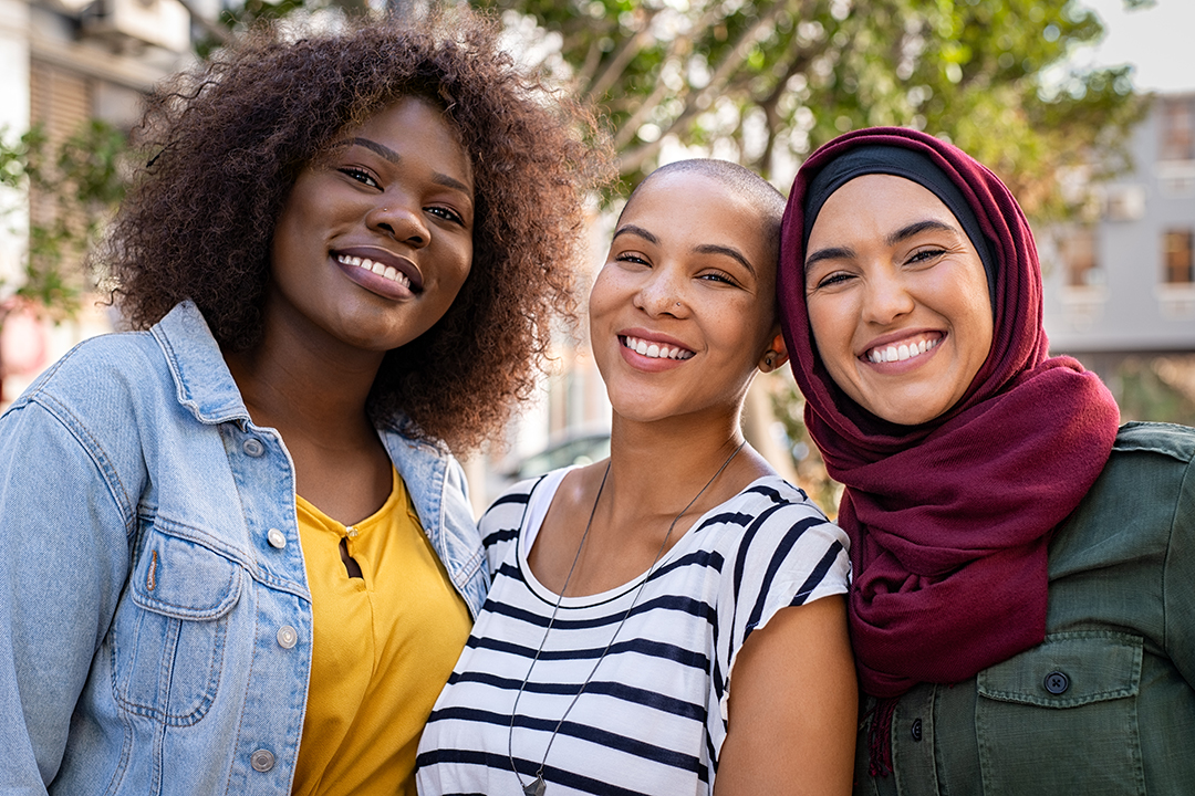 Chicagoland Women Group of three happy multiethnic friends looking at camera.